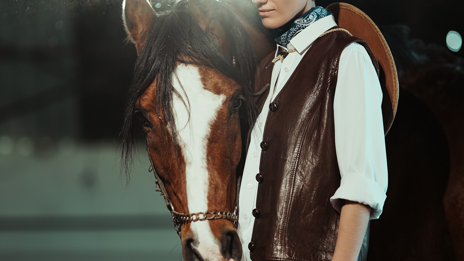 Cavalier aupres de son cheval dans une ecurie